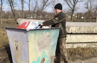 Викидає сміття в урну, Богоявленський парк